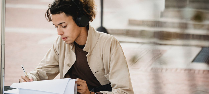 A student reading and wearing headphones